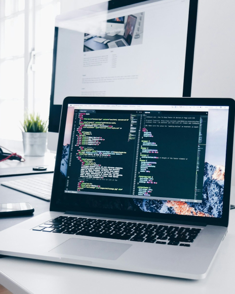 Modern developer workspace with laptop displaying code. Professional programming setup for software development.